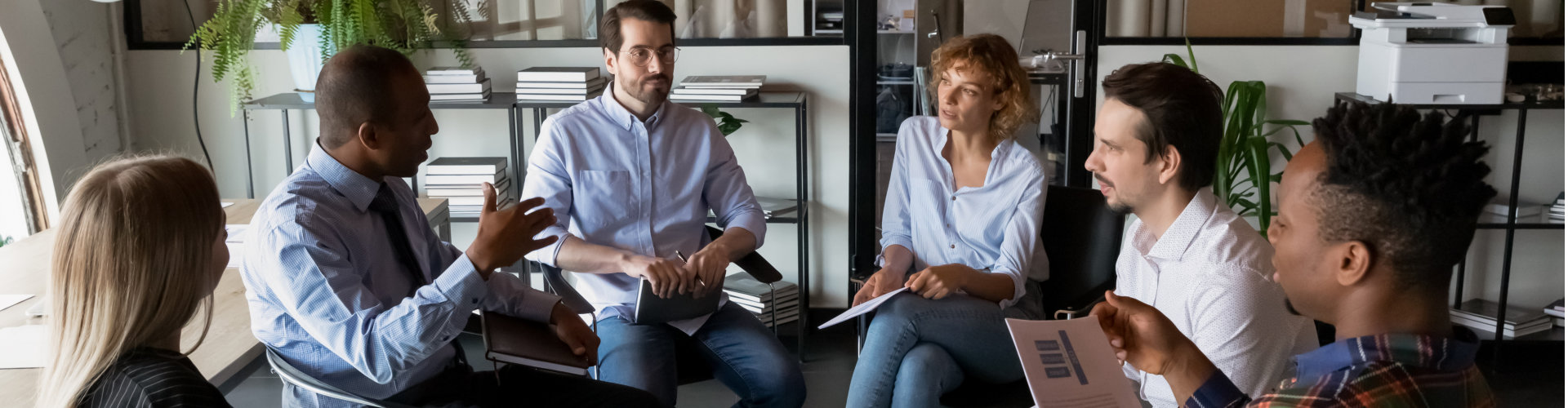 business team coworkers sitting in circle in office