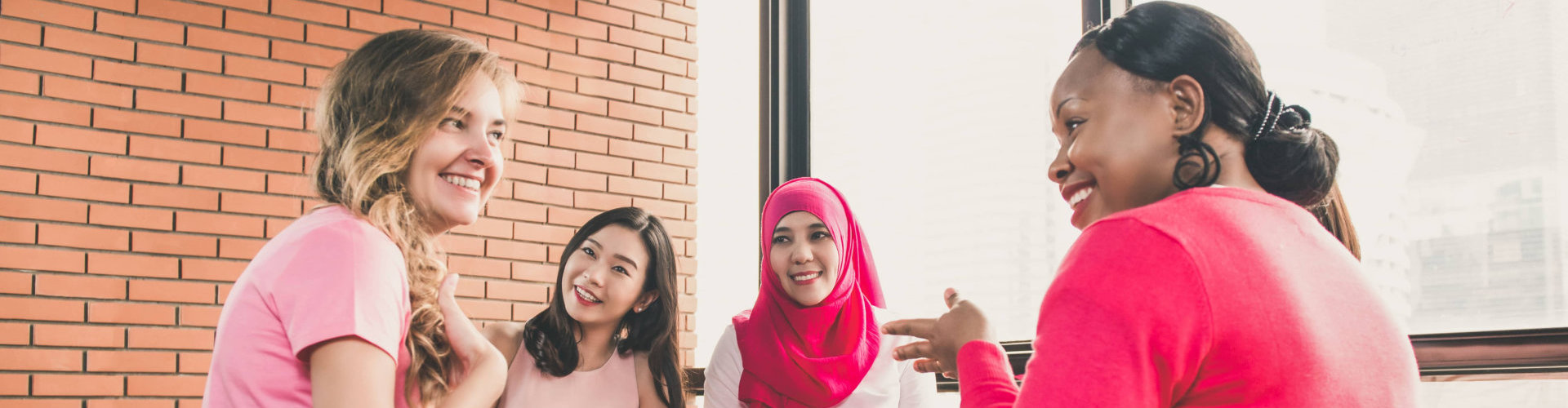 women wearing pink color clothes sitting in circle talking and meeting